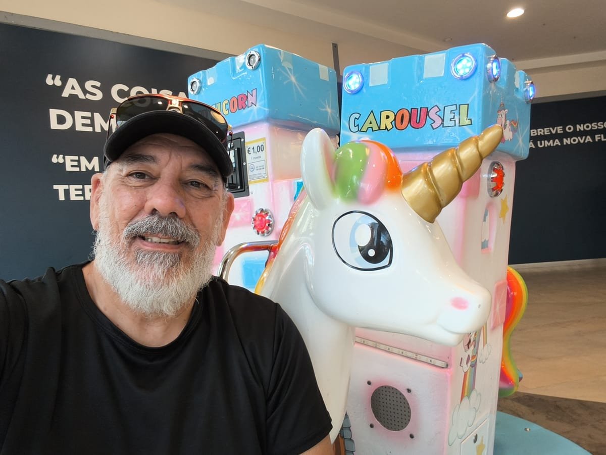Nelson Viegas ao lado de um unicórnio de moeda para crianças, num centro comercial
